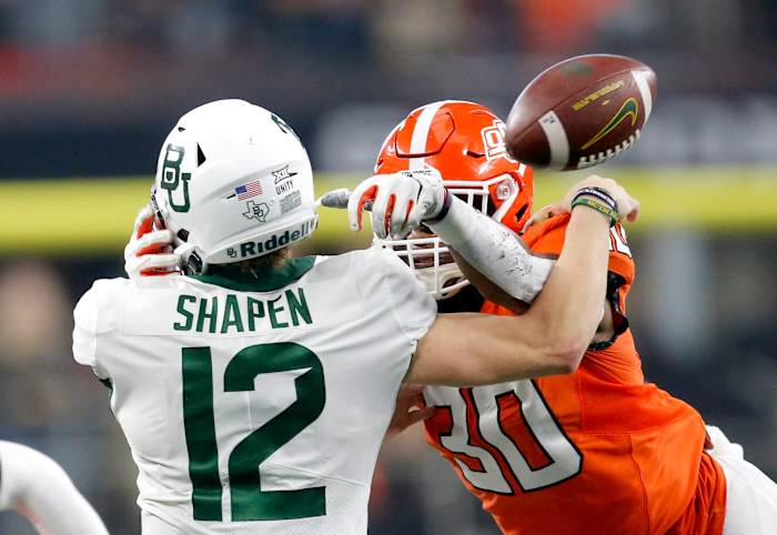 Oklahoma State University's Collin Oliver (30) sacks Baylor's Blake Shapen (12) and forces him to fumble out of bounds in the Big 12 title game. cover